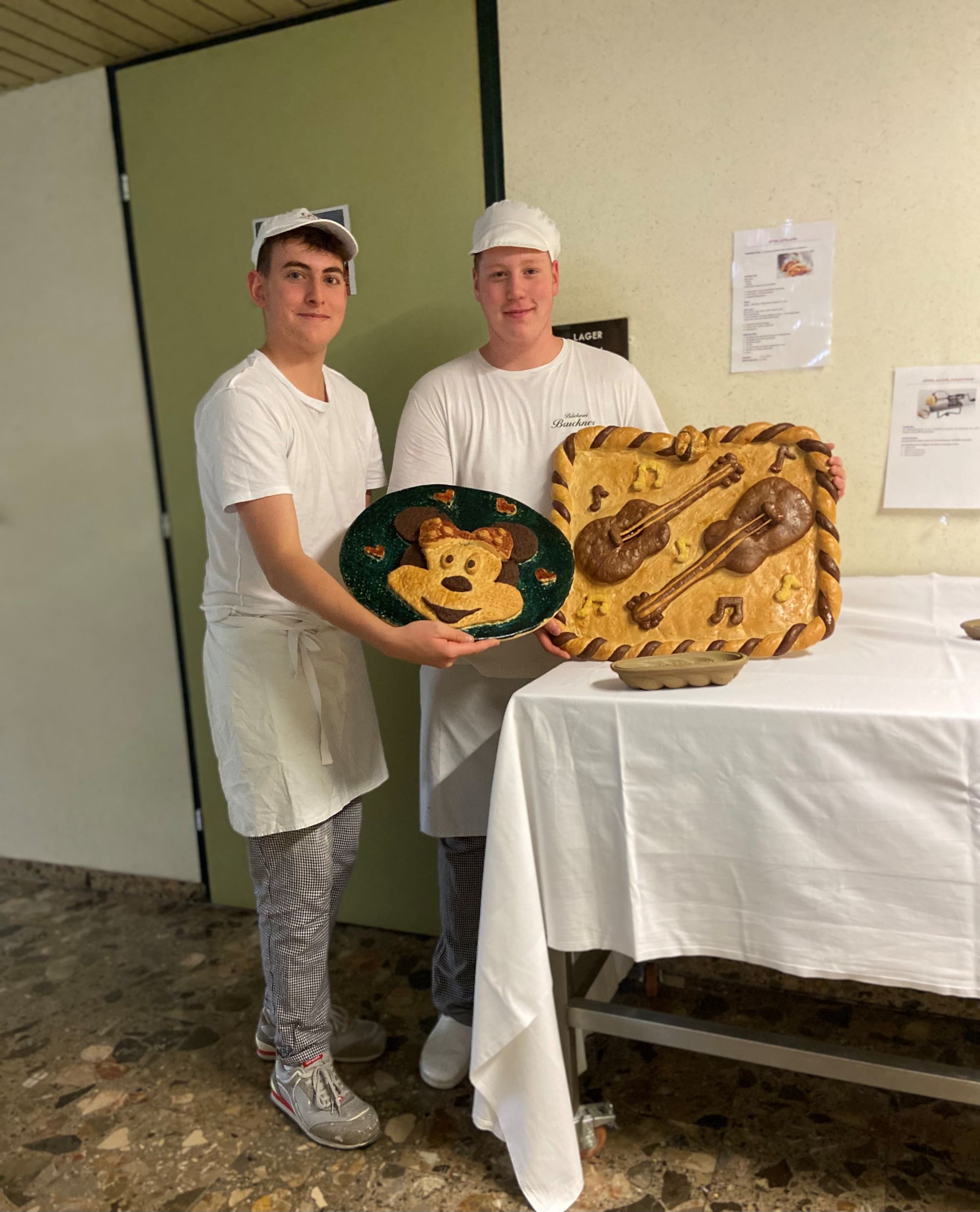Es werden zwei Bäckereilehrlinge mit ihren Kreationen gezeigt.